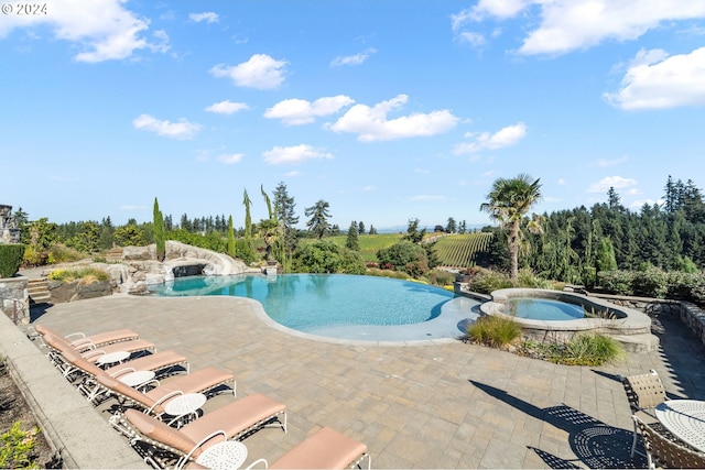 view of pool with a patio and an in ground hot tub