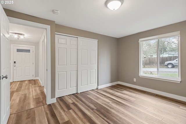 unfurnished bedroom featuring a closet and light hardwood / wood-style flooring