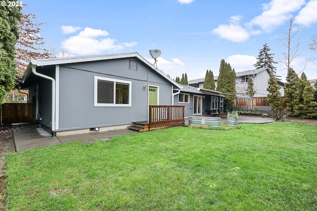 rear view of property with a yard and a wooden deck