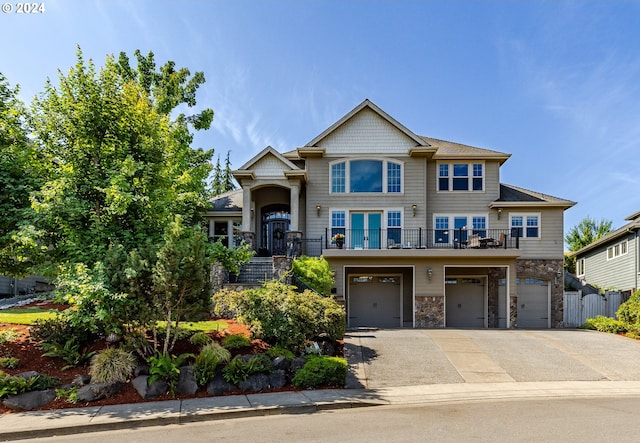 craftsman-style house with an attached garage, stone siding, a balcony, and concrete driveway