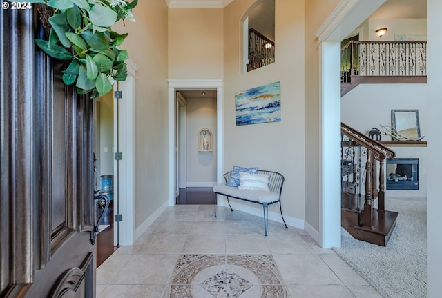 entryway featuring crown molding and light tile patterned floors