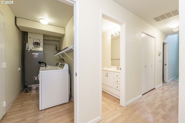 17760 NW Rolling Hill Ln, Beaverton, OR 97006 - washroom featuring washer / clothes dryer, light wood-style flooring, baseboards, and heating unit