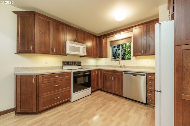 17760 NW Rolling Hill Ln, Beaverton, OR 97006 - kitchen with white appliances, light wood-style flooring, a sink, and light stone countertops