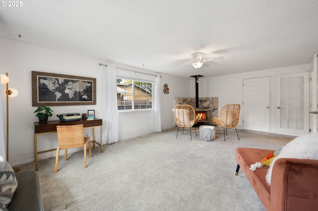 266 NE 193rd Ave, Portland, OR 97230 - sitting room with a wood stove, ceiling fan, carpet, and a textured ceiling