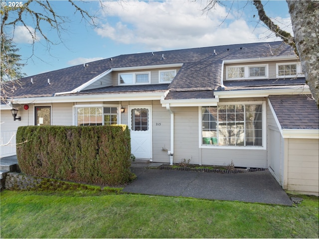 view of front of home featuring a shingled roof and a front yard