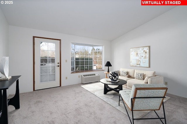 living room with vaulted ceiling, carpet, and a wall unit AC