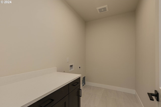 washroom featuring washer hookup, electric dryer hookup, and cabinets