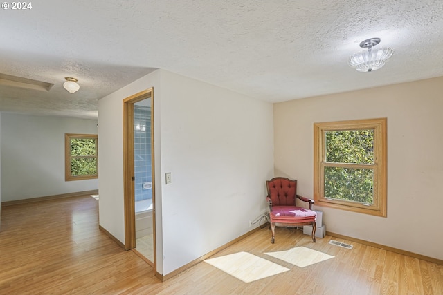 living area featuring light hardwood / wood-style floors and a textured ceiling