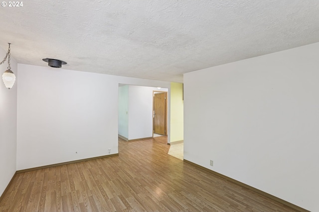 spare room featuring wood-type flooring and a textured ceiling