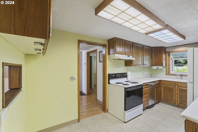 kitchen with light hardwood / wood-style flooring, a textured ceiling, and white appliances