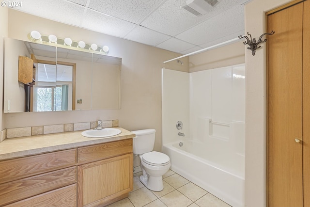 full bathroom with toilet, tile patterned flooring, a drop ceiling, vanity, and washtub / shower combination