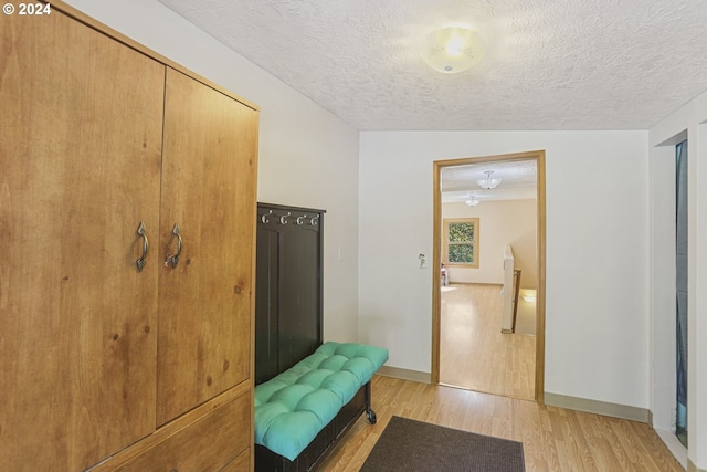 mudroom featuring a textured ceiling and light wood-type flooring