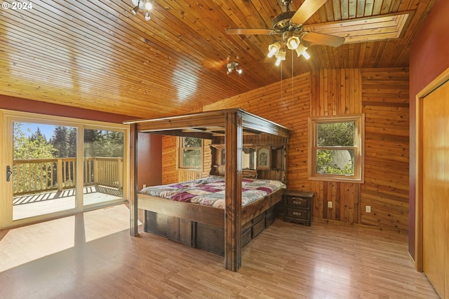 bedroom with lofted ceiling, wooden walls, wood ceiling, and light hardwood / wood-style floors