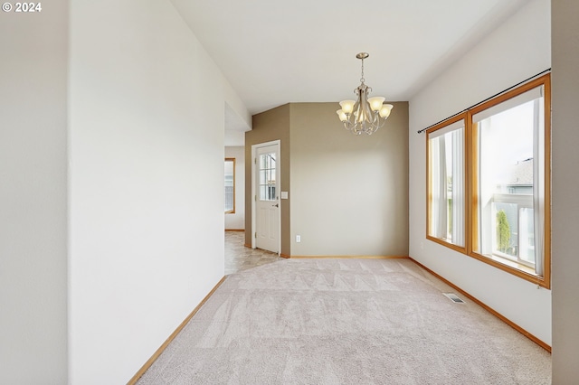 carpeted empty room with an inviting chandelier