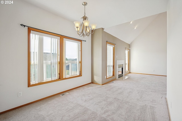 unfurnished living room with a chandelier, carpet floors, and vaulted ceiling