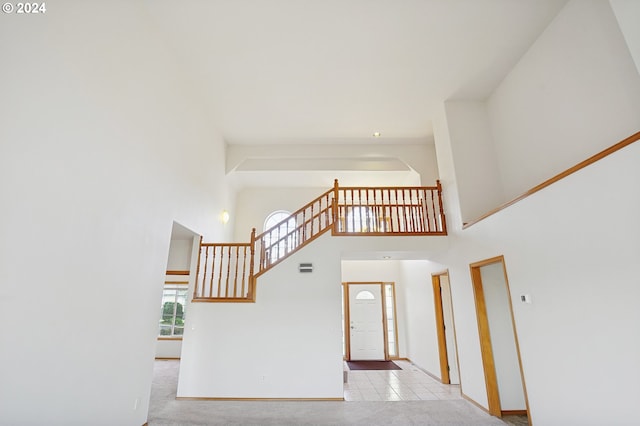 staircase with carpet floors and a high ceiling