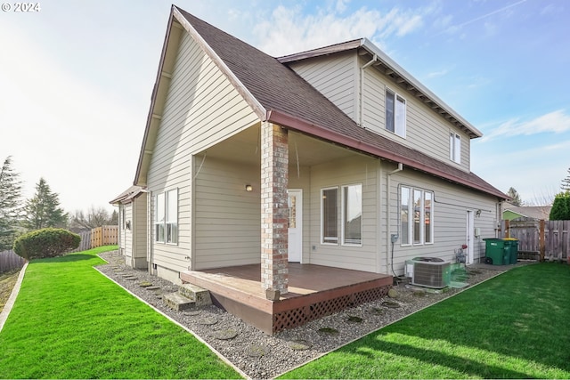 rear view of house featuring a lawn, a wooden deck, and central air condition unit