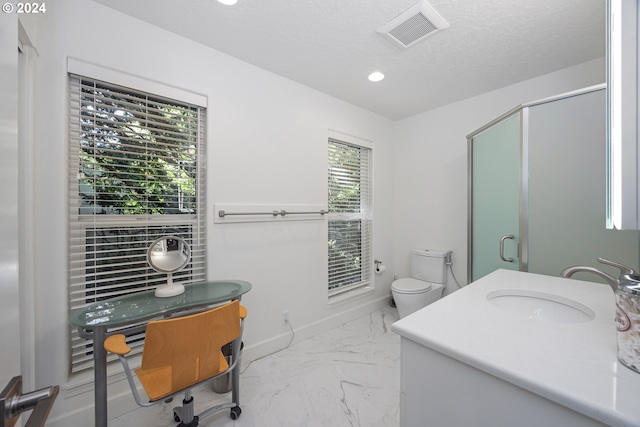 bathroom featuring a wealth of natural light, walk in shower, vanity, and toilet