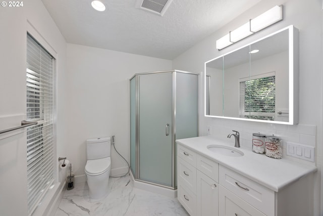 bathroom featuring a textured ceiling, backsplash, a shower with door, vanity, and toilet