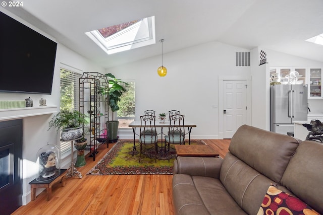 living room with hardwood / wood-style floors and lofted ceiling with skylight