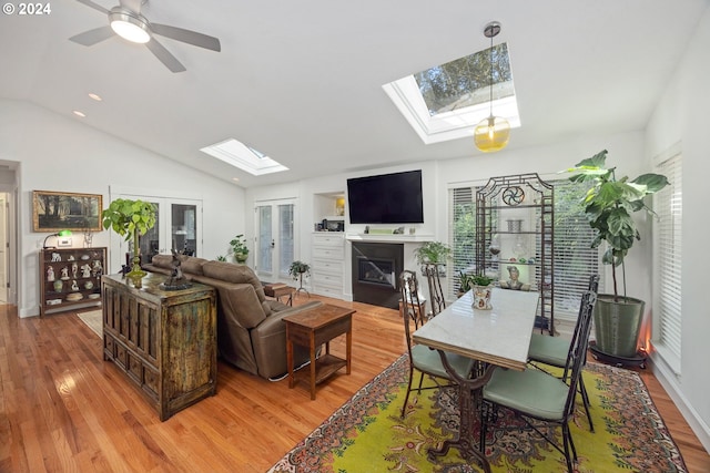 living room featuring light wood-type flooring, vaulted ceiling, ceiling fan, and french doors