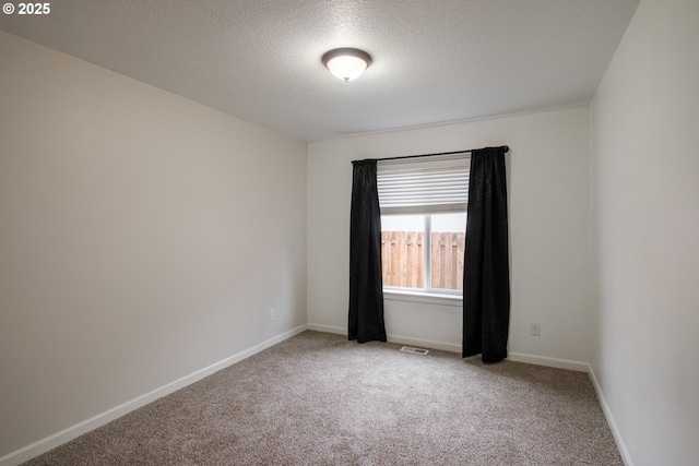 unfurnished room featuring a textured ceiling, carpet flooring, visible vents, and baseboards