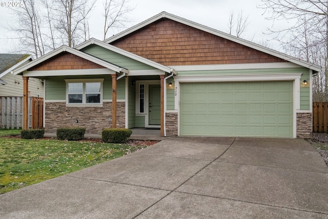 craftsman-style house featuring a garage, stone siding, fence, and concrete driveway