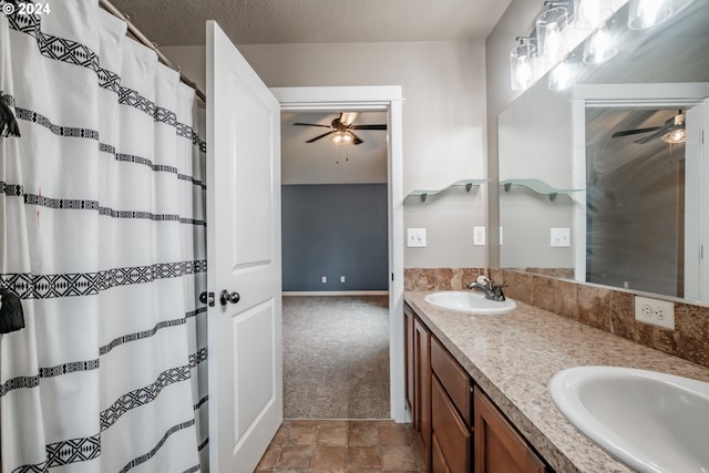 bathroom with ceiling fan, vanity, and a textured ceiling