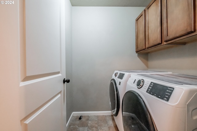 laundry area with washer and dryer and cabinets