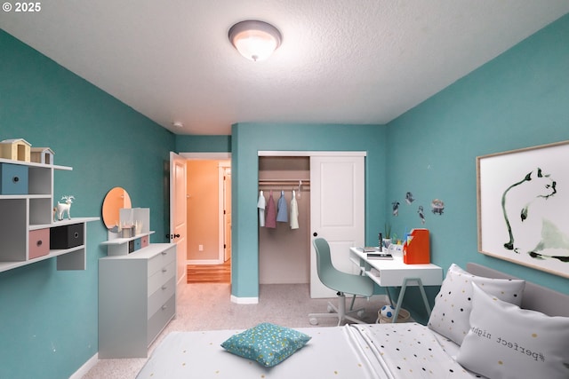 bedroom with a closet, a textured ceiling, and baseboards