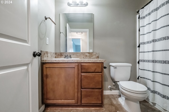 bathroom with toilet, a shower with curtain, vanity, and tile patterned floors