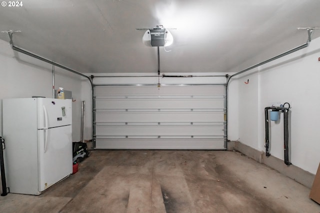 garage with a garage door opener and freestanding refrigerator