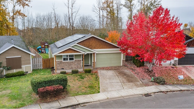 view of front of home featuring a front lawn, a garage, and solar panels