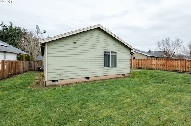 back of property featuring a yard, central AC unit, and a fenced backyard