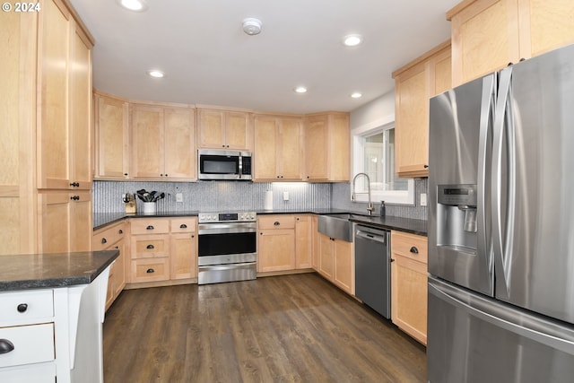 kitchen featuring stainless steel appliances, light brown cabinetry, sink, and dark hardwood / wood-style flooring