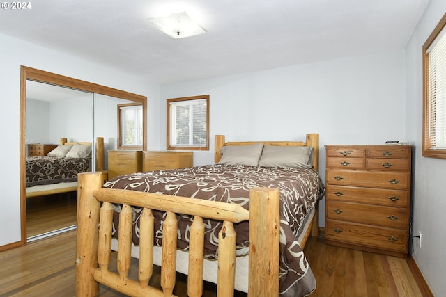 bedroom with dark wood-type flooring and a closet