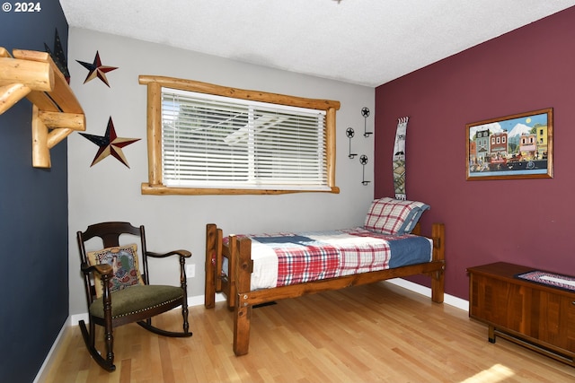 bedroom with a textured ceiling and light wood-type flooring