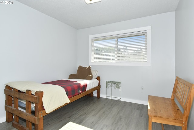 bedroom with a textured ceiling and hardwood / wood-style flooring