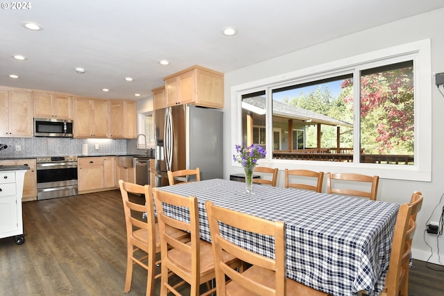 kitchen with dark hardwood / wood-style floors, stainless steel appliances, backsplash, sink, and light brown cabinetry