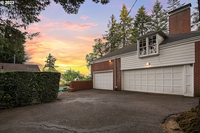 view of garage at dusk