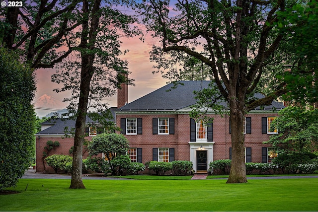 colonial inspired home with a yard