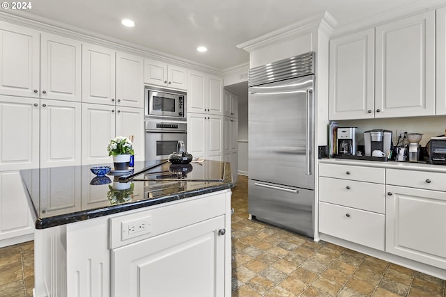 kitchen featuring built in appliances, white cabinetry, and light tile floors