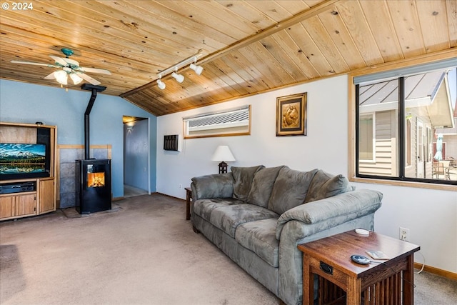 living room featuring wooden ceiling, a wood stove, track lighting, carpet flooring, and ceiling fan