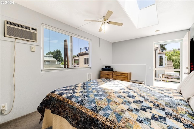 carpeted bedroom with ceiling fan, an AC wall unit, and a skylight