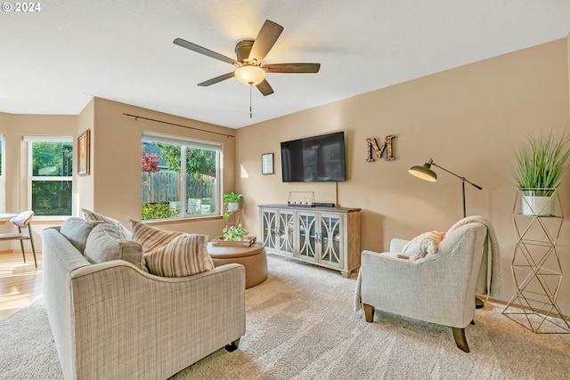 carpeted living room with ceiling fan