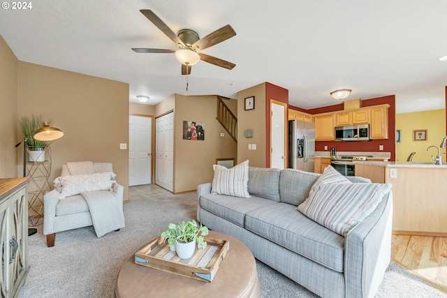 living room with sink, light carpet, and ceiling fan