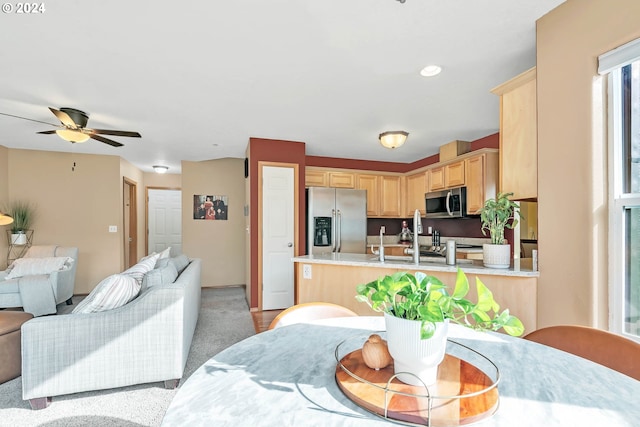 kitchen featuring light carpet, light brown cabinets, kitchen peninsula, ceiling fan, and stainless steel appliances