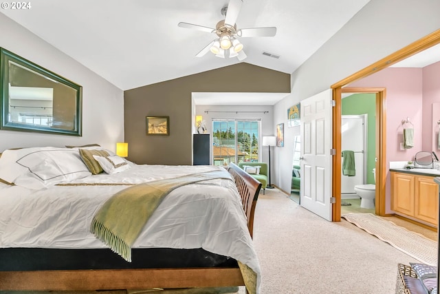 bedroom with visible vents, lofted ceiling, light carpet, connected bathroom, and a ceiling fan
