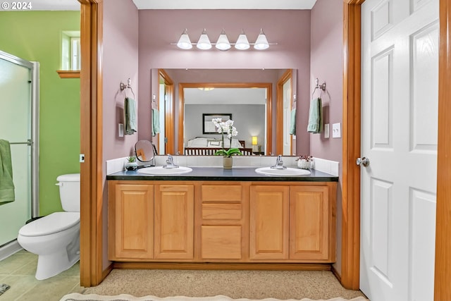 bathroom featuring toilet, vanity, and a shower with door