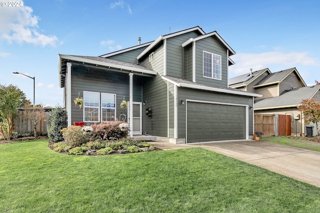 traditional-style home with fence, driveway, a front yard, and a garage